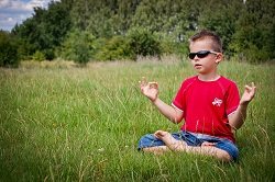 Meditating kid in sunglasses