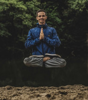 Man sitting in meditation posture floating off the group