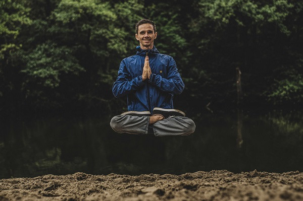 Man sitting in meditation posture floating off the group