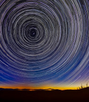 stars spiralling outwards in the night sky