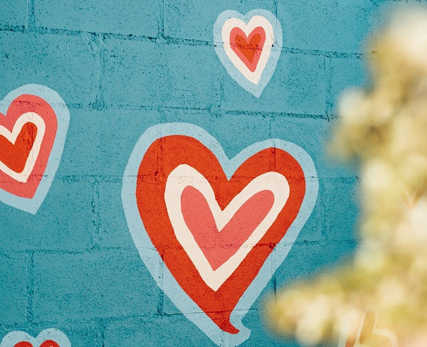 Painted hearts on a blue brick wall