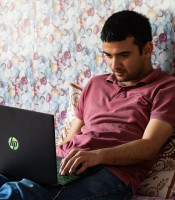 Man working on a laptop on his bed