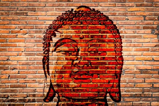 Buddha head painted on a brick wall