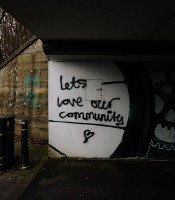 Concrete underpass with graffiti saying let's love our community