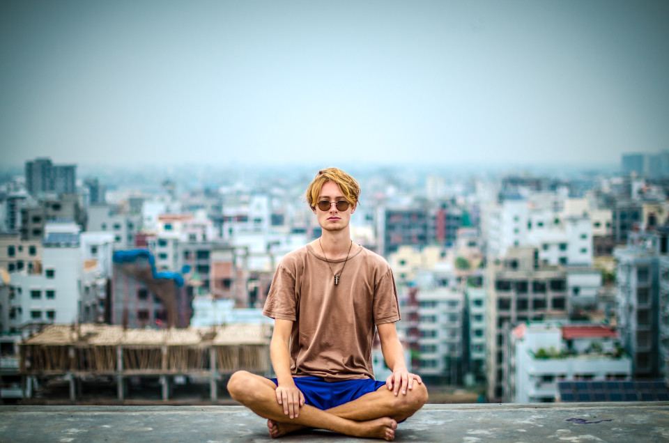 Man meditating on a rooftop in the city