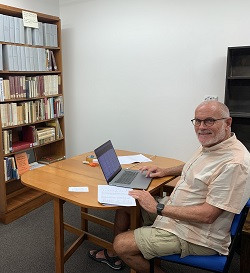 Buddhanusarin sitting at work on his laptop in the library