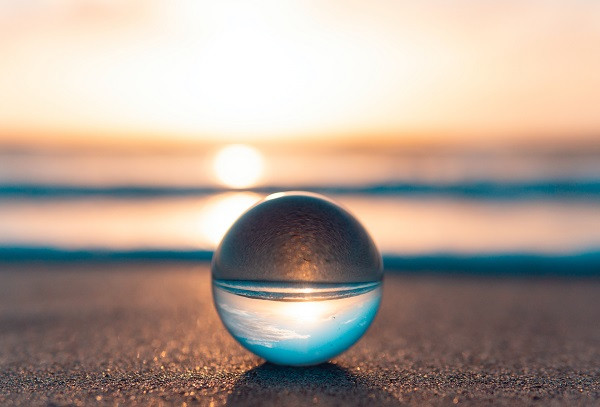 Clear ball reflecting a beach and the sun